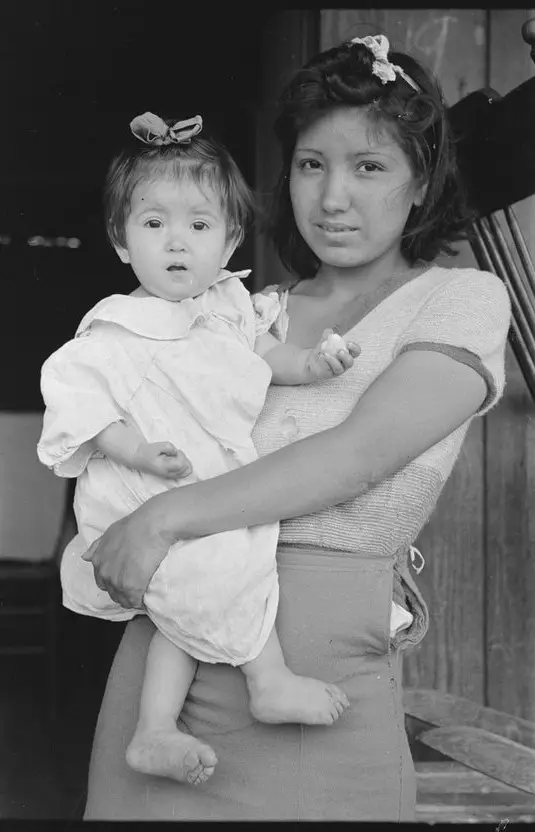 Black and white portrait of a young mother holding her baby